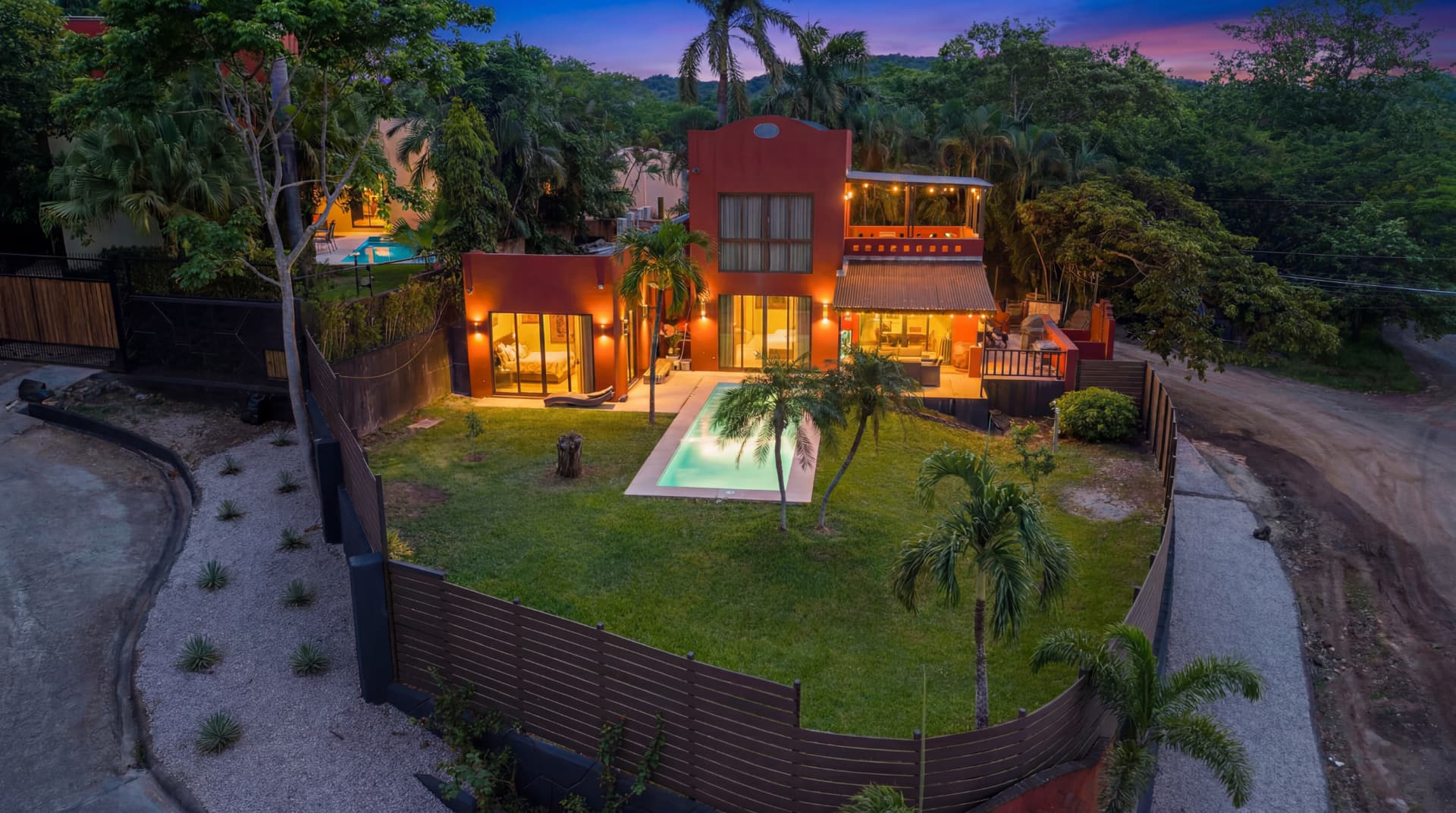 Aerial view of the house and pool at twilight